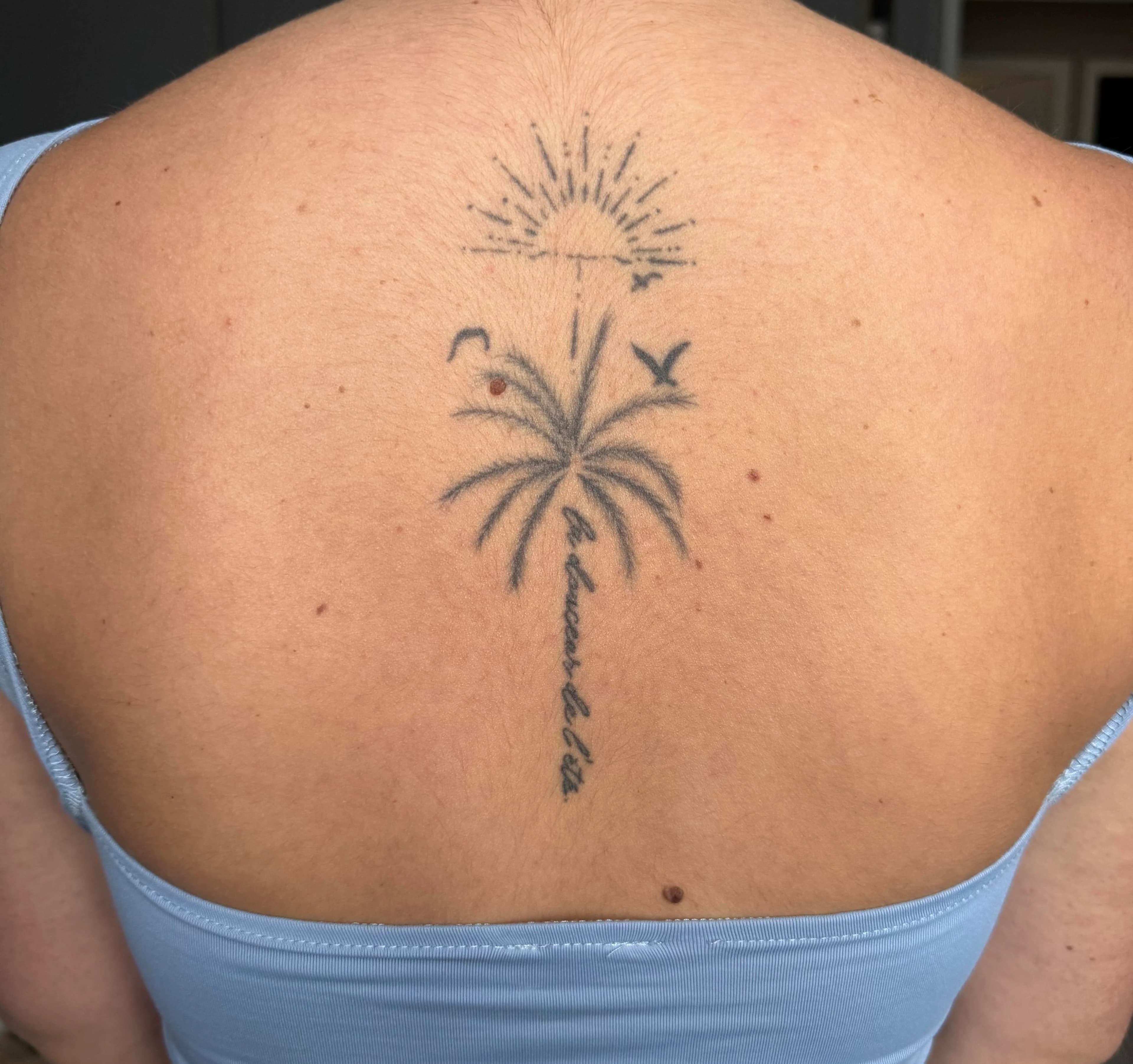 Le tatouage de Marine — palmier, oiseaux et soleil avec la douceur de l'été